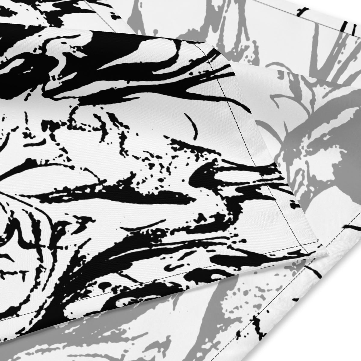 Close-up of Ink-Riot Bandana fabric showing black ink-riot graphic print detail and double-folded edge stitching