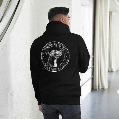 Person wearing a black hoodie with a graphic on the back in a minimalistic indoor setting